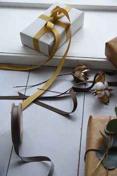 two wrapped presents sitting on the floor next to each other with ribbons tied around them