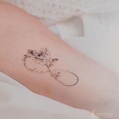 a woman's arm with a flower tattoo on the left side of her leg