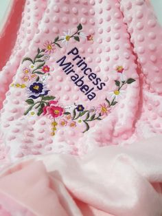 a pink blanket with flowers on it and the words princess mirabella written in white