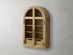 an arched wooden cabinet with drawers on the side and shelves below it, against a gray wall