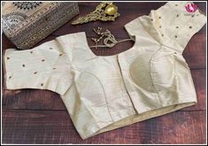 This is a cream color raw silk blouse with golden chumki work. This has a beautiful back neck with dori in the back and has a standard front opening. It fits size 40. It is a classy blouse perfect to pair with silk sarees. Size: 40 Please note: Color may vary slightly from the picture. Loose threads and pulled threads are common in embroidered clothing and it is not a defect. Festive Cream Raw Silk Blouse Piece, Cream Raw Silk Saree Blouse Piece, Cream Raw Silk Blouse Piece For Saree, Elegant Beige Blouse Piece With Zari Work, Gold Silk Tops With Cutdana Detailing, Festive Beige Blouse With Cutdana, Elegant Cream Traditional Wear With Unstitched Blouse, Bollywood Beige Blouse With Pallu, Bollywood Style Beige Blouse With Pallu