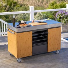 an outdoor bbq with pizza on the grill and cutting board in front of it