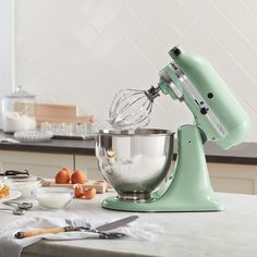 Enamelled in creamy green, this KitchenAid Artisan Series stand mixer charms on countertops. From mixing cake batter and whipping cream to kneading bread dough and shredding chicken, you'll find endless uses for this heavy-duty mixer that's built to last. The Artisan Series tilt-head stand mixer features ten-speed control with settings from very slow stirring to high-speed beating. Its five-quart stainless bowl with ergonomic handle accommodates large batches of your favorite recipes, and the ti Pistachio Kitchenaid, Shredding Chicken, Kitchenaid Artisan Stand Mixer, Pasta Makers, Bread Maker Machine, Pasta Roller, Tilt Head, Kitchenaid Artisan, Stainless Steel Mixing Bowls