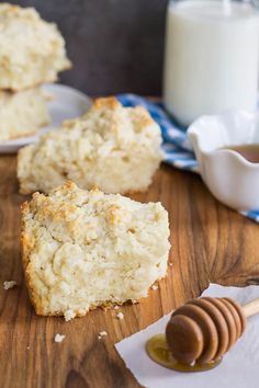 two pieces of scones sitting on top of a wooden cutting board next to a glass of milk