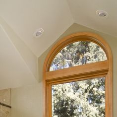 a bathroom with a large window, sink and bathtub in front of the tub