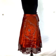 Our double layer Midi Lotus Flower Aari Skirt is a stunning decorative wrap around skirt that hugs your waist & hips, letting the elegant embroidered cloth do the rest!   The vintage sheer outer material is elaborately decorated & finished in traditional Aari style.  Handmade from fine quality vintage Silk saris ensuring every dress is unique just like you!  In India, these sari are very popular wear at weddings and parties.  The under-layer is a vibrant satin material that shimmers as you move. Festive Embellished Traditional Drape Skirt, Festive Embellished Skirt With Traditional Drape, Festive Embellished Long Skirt, Bollywood Style Embellished Festive Skirt, Bollywood Festive Embellished Skirt, Festive Bollywood Embellished Skirt, Embellished Skirt For Party And Festivals, Festive Fitted Skirt With Intricate Embroidery, Traditional Embellished Long Skirt