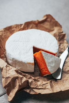 a piece of cheese sitting on top of a table next to a knife