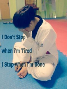 a woman kneeling down on top of a blue mat