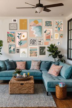 a living room with blue couches and pictures on the wall above it, along with a coffee table