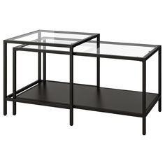 two black tables with glass tops on each side and one shelf below the table is empty