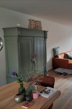 a living room filled with furniture next to a wooden table and couch on top of a hard wood floor