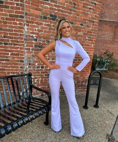 a woman standing in front of a brick wall