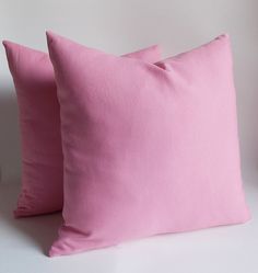 two pink pillows sitting next to each other