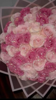 a bouquet of pink and white flowers on top of a table