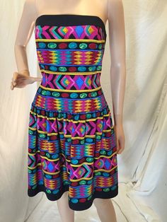 Stunning vintage matching two piece outfit from A.J. Bari.  The dress is strapless and 100% silk with a bold and vibrant multicolor tribal geometric print with pink, black, blue, red, and yellow.  Size 10.  Fitted bodice and full skirt. The jacket is black 100% cotton in a size 12.  Long sleeves and cropped bolero style. Both pieces are in excellent condition, normal wear.  See photos for more details. Pit to Pit - approximately 15.5" across Pit to bottom hem - approximately 30.5" Waist area - approximately 15" across Fitted Summer Dress With Geometric Pattern, Retro Fitted Dress With Colorful Pattern, Colorful Retro Fitted Dress, Colorful Pattern Retro Fitted Dress, Fitted Bohemian Colorful Dresses, Fitted Multicolor Dress With Geometric Pattern, Fitted Patterned Festival Dresses, Multicolor Stretch Retro Dresses, Retro Multicolor Stretch Dresses