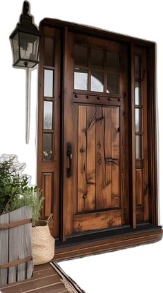 a wooden door with two sidelights and a planter