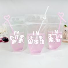 three plastic cups with i'm getting married printed on them and straws in the bags