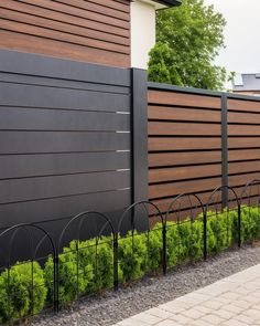 a black fence next to a brown building