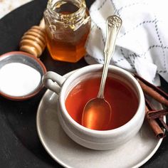 a cup of tea and spoon on a plate