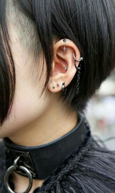 a close up of a person with piercings on their ears and behind the ear