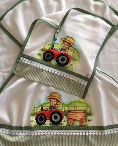 two aprons with pictures of farm animals on them, one has a tractor and the other has a farmer