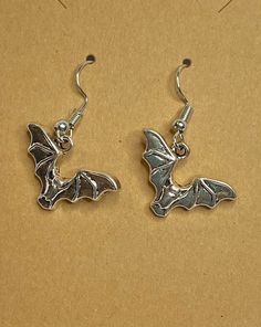 Cute little bats fluttering around at the end of a surgical stainless steel ear wire. For the dark side in all of us, what better way to say "Batty", than this.Any metals used in jewelry are all nickel free, tarnish resistant (except for copper, which will change color(patina) over time). Metals are either bare copper, silvertone, or goldtone, unless otherwise stated. Nickel-free Themed Stainless Steel Jewelry, Themed Nickel-free Stainless Steel Jewelry, Hypoallergenic Drop Earrings For Halloween, Halloween Hypoallergenic Metal Jewelry, Gothic Hypoallergenic Metal Jewelry, Novelty Metal Earrings With Ear Wire, Gothic Silver Surgical Steel Earrings, Hypoallergenic Surgical Steel Earrings, Themed Silver Earrings For Halloween