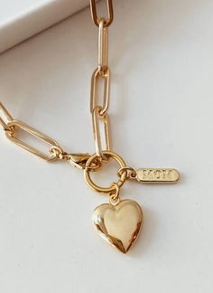 18k Gold paperclip chain with a dazzling 18K Gold Heart locket and elegant 'Mom' tag. 16" Length. Calling all Moms - This is a perfect "Mom" Gift. Oceanne is a Women-Owned Company we Adore! Océanne is a tribute to owner, Anne Harrill’s childhood in France & her journey to the American Midwest. Geometric and minimalist metalworking, minerals, stones, and conversational phrases are elements in our designs. With great attention to detail, each piece is made by hand using traditional techniques such American Midwest, Gold Heart Locket, Owl Jewelry, Diffuser Bracelets, Mom Necklace, Heart Locket, Perfect Gift For Mom, Beaded Jewelry Diy, Gold Heart