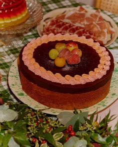 there is a cake on the table with fruit toppings in the shape of a heart