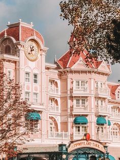 a large pink building with a clock on it's face