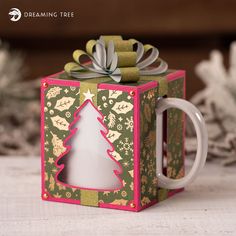 a coffee mug with a christmas tree on the inside is sitting in a gift box