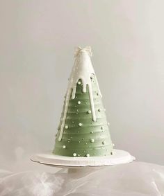 a green and white christmas tree cake on top of a paper plate with icing