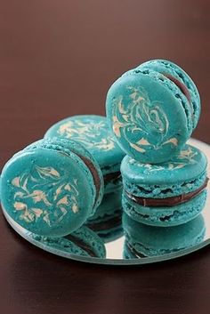 three blue macaroons stacked on top of each other with frosting and icing