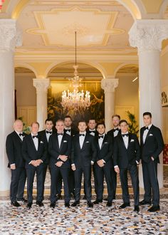 a group of men standing next to each other in tuxedos