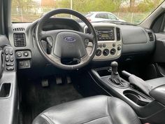 the interior of a car with black leather seats and steering wheel, dashboard controls and dash board