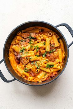 a pot filled with pasta and meat on top of a table