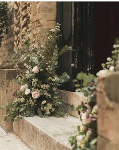 flowers are growing on the steps in front of a door