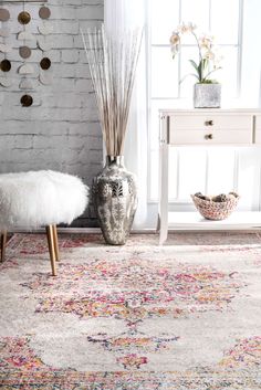 a room with a rug, mirror and vase on the floor