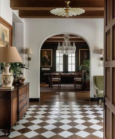 an open door leading to a living room with a chandelier hanging from the ceiling