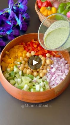 a bowl filled with vegetables and dressing next to other bowls full of food on a table