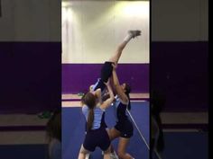 two girls are playing tennis on the court and one girl is reaching up to hit the ball with her racquet