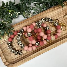 This silicone beaded wristlet is perfect for anyone that is on the go.  It is made with a strong elastic cord which allows it to easily slip on and off your wrist. You can even clip it to your purse, backpack, or diaper bag.     This wristlet is made of 100% food-grade silicone beads that are BPA free.  These wristlets are strung on heavy-duty elastic cord.   OPTIONS: Style 1 - leopard print beads with maroon and peach tones and a wooden accent bead Style 2 - leopard print  beads with maroon and Handmade Pink Bracelet For Everyday Use, Handmade Pink Bracelet For Everyday, Beaded Wristlet, Peach Tones, Keychain Bracelet, Boho Keychain, Custom Gift Wrapping, Purse Backpack, Wristlet Keychain