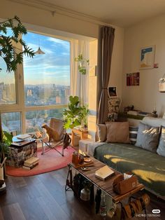 a living room filled with furniture and a large window overlooking the cityscape in the distance