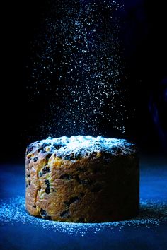 a cake is sprinkled with sugar on a dark background