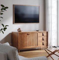 a flat screen tv mounted to the side of a wooden cabinet in a living room