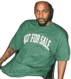 a man sitting on top of a chair wearing a green shirt with not for sale written on it