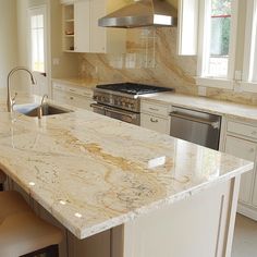 a kitchen with an island, stove and sink in it's center island area