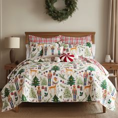 a christmas themed bed in a bedroom with wreath on the wall