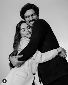 two people hugging each other in black and white