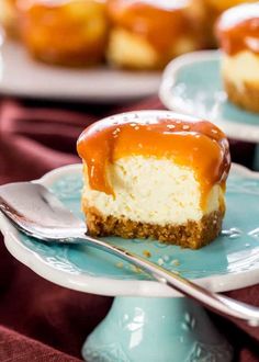 a piece of cheesecake with caramel drizzled on top is sitting on a blue plate