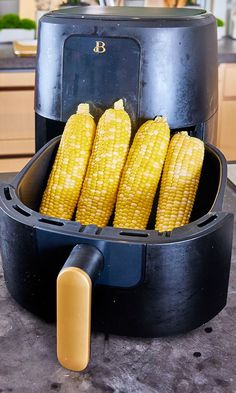 corn on the cob is being cooked in an air fryer and ready to be used